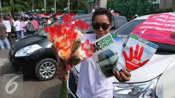 Seorang driver online memperlihatkan poster yang berisi tuntutannya saat unjuk rasa di depan DPR, Jakarta, Senin (22/8). Aksi tersebut untuk penolakan Peraturan Menteri Perhubungan (Permenhub) No 32 Tahun 3016. (Liputan6.com/Angga Yuniar)