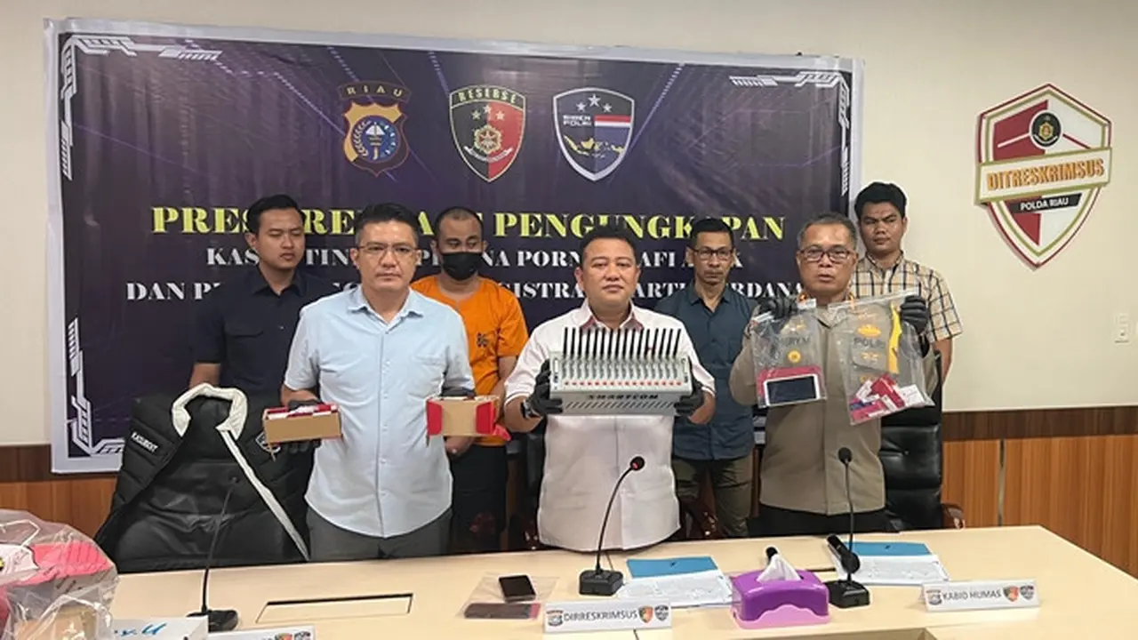 Tersangka penjual kartu perdana seluler teregister dengan data kependudukan orang lain dalam konferensi pers yang digelar Polda Riau.