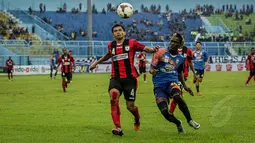 Pemain Belakang Persipura, Ricardo Salampesy berduel udara dengan penyerang Arema Yao Rudy saat laga SCM Cup 2015 di Stadion Kanjuruhan, Malang, Kamis (22/1/2015) Arema Cronus menang 4-1 atas Persipura (Liputan6.com/Faizal Fanani)