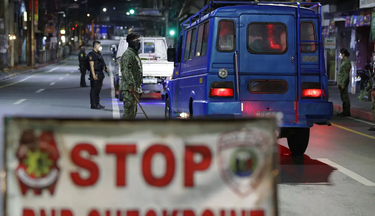 Polisi memeriksa kendaraan saat jam malam diberlakukan untuk mencegah penyebaran COVID-19 di Metro Manila, Filipina, Senin (15/3/2021). Lonjakan kasus COVID-19 di Filipina menambah kekhawatiran atas lambannya vaksinasi dan keengganan publik. (AP Photo/Aaron Favila)