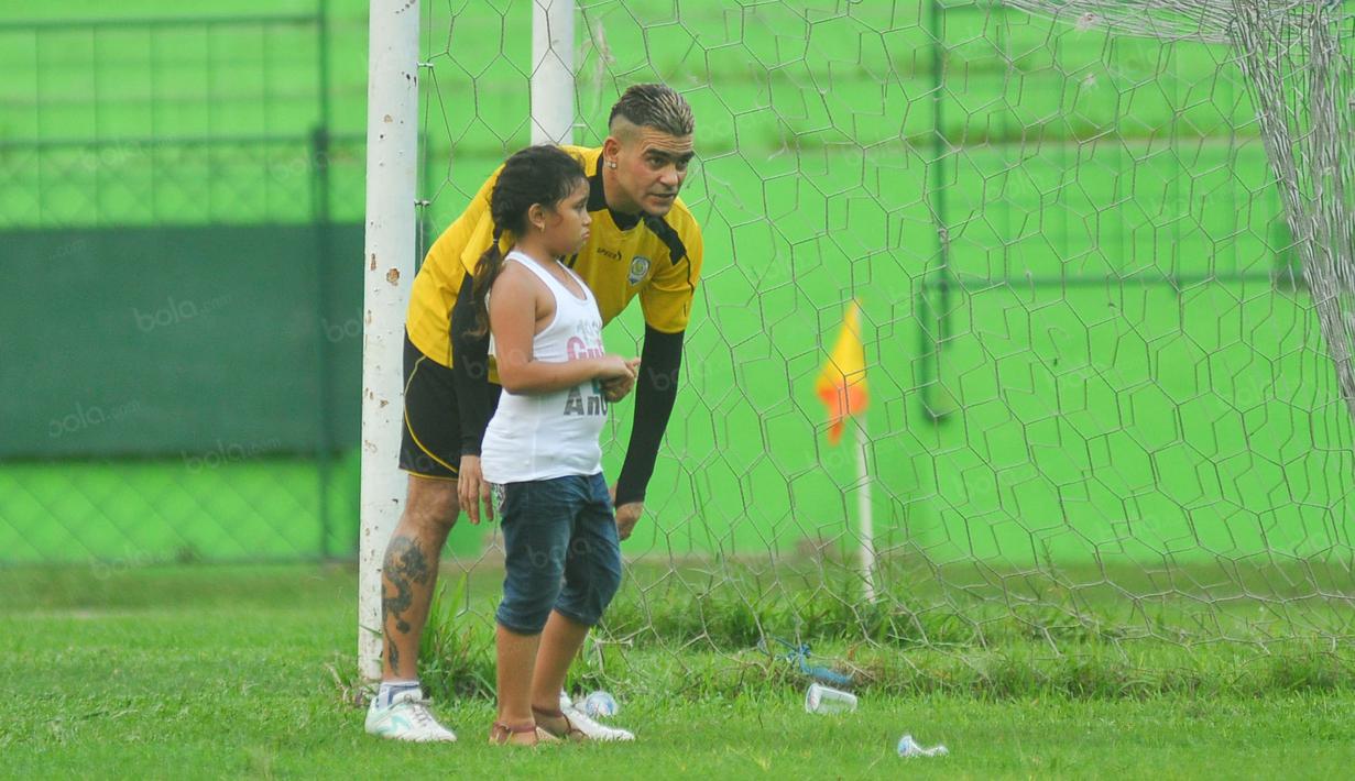 Cristian Gonzales ditemani anaknya, Vanessa pada sesi latihan di Stadion Gajayana, Malang, Senin (23/5/2016). (Bola.com/Iwan Setiawan)