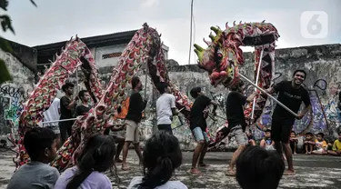 Anak-anak menyaksikan anggota Naga Merah Putih saat latihan Liong di kawasan Babakan Pasar, Bogor, Jawa Barat, Senin (17/1/2022). Jelang perayaan Tahun Baru Imlek, klub kesenian Tionghoa tersebut rutin melakukan latihan memainkan Liong dan Barongsai. (merdeka.com/Iqbal S. Nugroho)