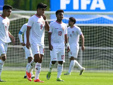 Timnas Indonesia akhirnya gagal meraih tiket terakhir ke Olimpiade Paris 2024 usai takluk 0-1 dari Guinea U-23 pada laga play-off antar-konfederasi menuju Olimpiade Paris 2024 di Stade Pierre Pibarot, Centre National du Football de Clairefontaine, Prancis, Kamis (9/5/2024). Gol tunggal kemenangan Guinea dicetak melalui eksekusi penalti Ilaix Moriba pada menit ke-29. Keputusan penalti yang diberikan wasit Francois Letexier terbilang kontroversial, karena Witan Sulaeman menjatuhkan pemain Guinea masih di luar kotak penalti. Keputusan kontroversial kembali diulangi wasit berkelas Liga Champions Eropa tersebut dengan kembali mengganjar penalti Garuda Muda pada menit ke-73, padahal tekel Alfeandra Dewangga jelas-jelas terlebih dahulu mengenai bola saat berduel dengan Algassime Bah di dalam kotak penalti. (AFP/Miguel Medina)