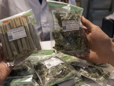 Pengunjung membeli aneka jenis ganja yang dijual di apotek ganja di Tel Aviv, Israel (2/3/2016). Apotek ganja ini menjual berbagai jenis ganja medis serta olahannya untuk kesehatan. (AFP Photo/Jack Guez)