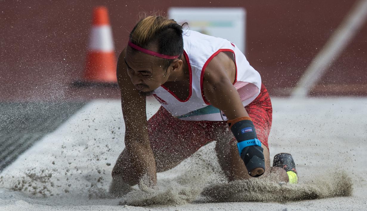 Atlet lompat jauh Indonesia, Settiyo Budi Hartanto, mendarat saat tampil pada cabang atletik nomor lompat jauh  T 45/46/47 Asian Para Games di SUGBK, Jakarta, Senin (8/10/2018). (Bola.com/Vitalis Yogi Trisna)