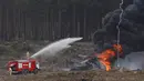 Pemadam kebakaran berupaya memadamkan helikopter Mi-28N yang jatuh terbakar saat kompetisi penerbangan militer "Aviadarts" di Dubrovichi, Rusia, Minggu (2/8/2015). Akibat kejadian tersebut, satu dari dua orang pilot tewas. (REUTERS/Maxim Shemetov)