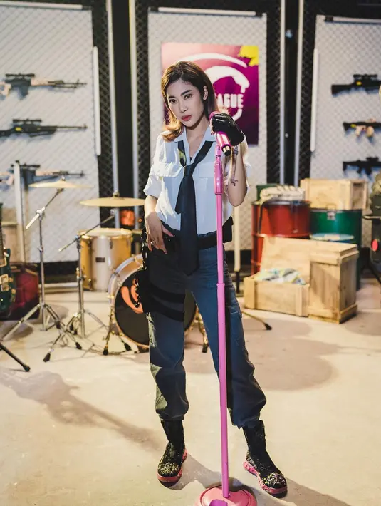 Kolaborasi dengan PUBG Mobile, Widi Vierratale costplay jadi karakter game. Mengenakan kemeja putih dan celana cargo abu-abu yang dilengkapi dengan boots dan dasi. [instagram/widikidiwdkdw]