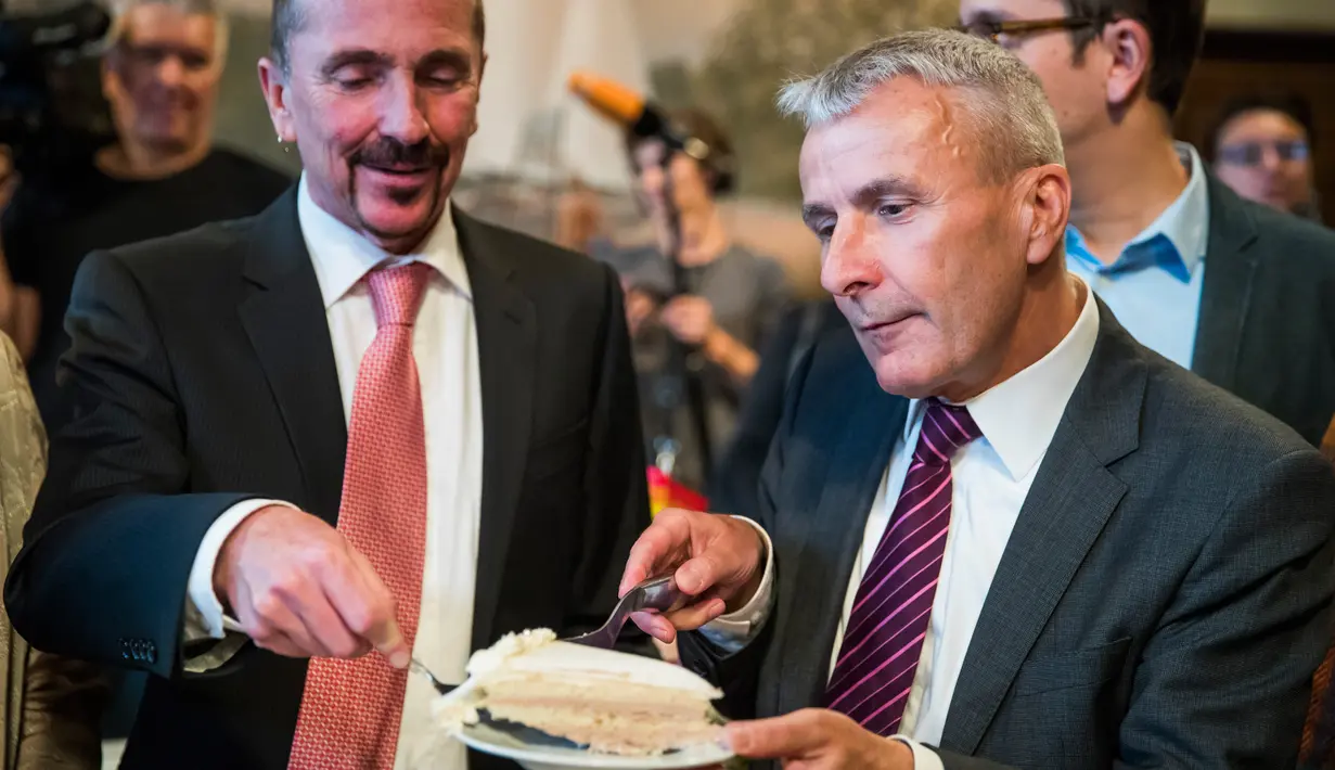 Pasangan gay, Bode Mende (kanan) dan Karl Kreile berbagi kue usai upacara pernikahannya di balai kota Schoeneberg di Berlin, Jerman (1/10). Pasangan yang telah menjalin cinta selama 38 tahun tersebut resmi menikah di Berlin. (AFP Photo/Odd Andersen)