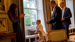 Presiden AS Barack Obama (kedua kanan) dan Pangeran William (kanan) memperhatikan Pangeran George yang tengah bermain dengan sang ibu, Kate Middleton di Kensington Palace, London, Jumat (22/4). (Kensington Palace/Pete Souza via Reuters)