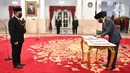 Presiden Joko Widodo menandatangani dokumen usai melantik Komisioner KPU I Dewa Kade Wiarsa Raka Sandi  di Istana Negara, Jakarta, Rabu (15/4/2020). (Antarafoto/Hafidz Mubarak/Pool)