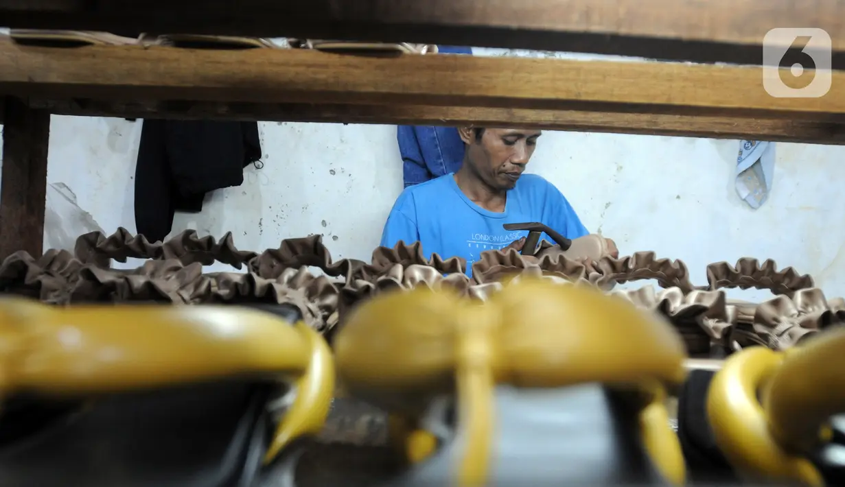 Perajin alas kaki menyelesaikan pembuatan sandal di kawasan Bojongsari, Depok, Jawa Barat, Selasa (22/2/2022). Dalam sebulan, perajin mampu menghasilkan 1.200 pasang sandal dengan harga Rp 30 ribu/pasang hingga Rp 200 ribu/pasang. (merdeka.com/Arie Basuki)