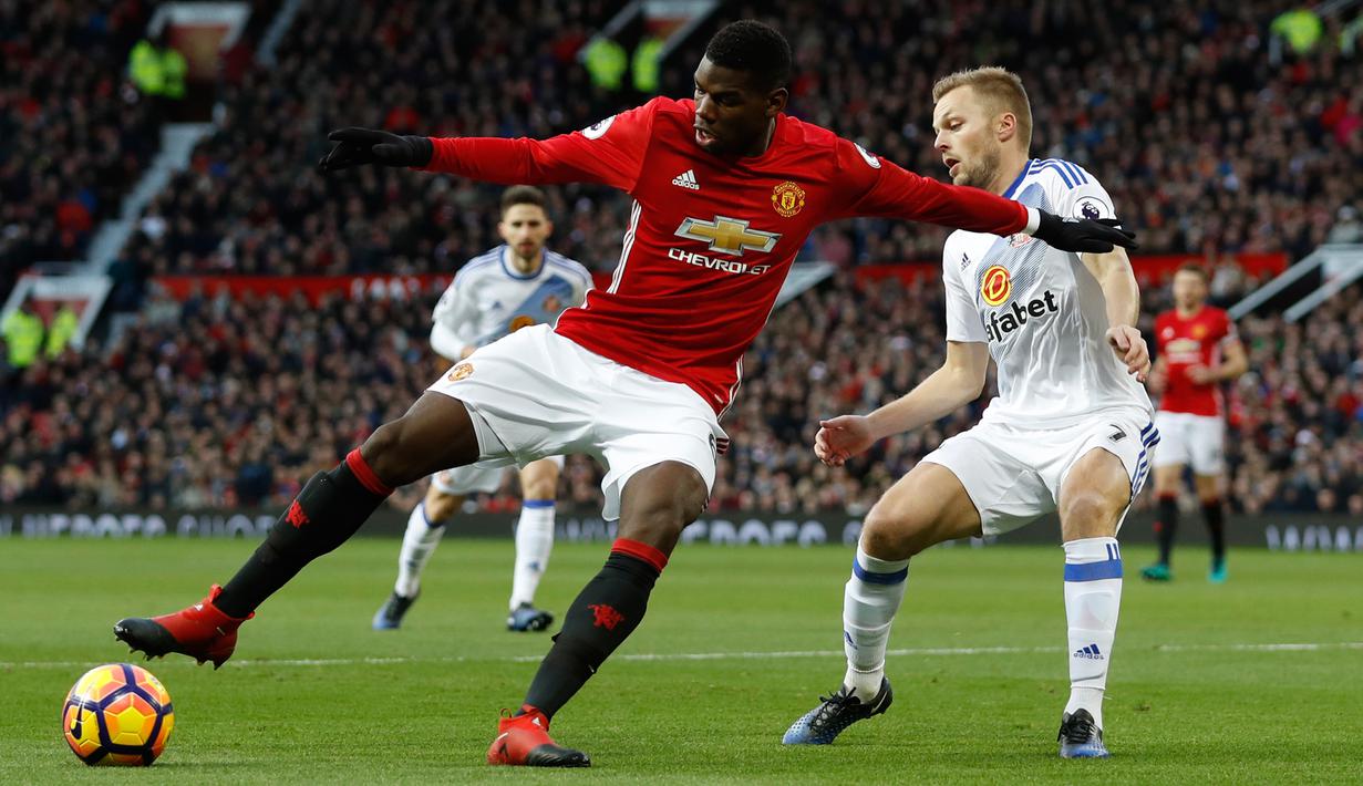 Gelandang Manchester United, Paul Pogba berusaha mengontrol bola dari hadangan gelandang Sunderland, Sebastian Larsson pada pertandingan Liga Inggris di Old Trafford, (26/12).MU menang atas Sunderland dengan skror 3-1. (Reuters/Lee Smith)