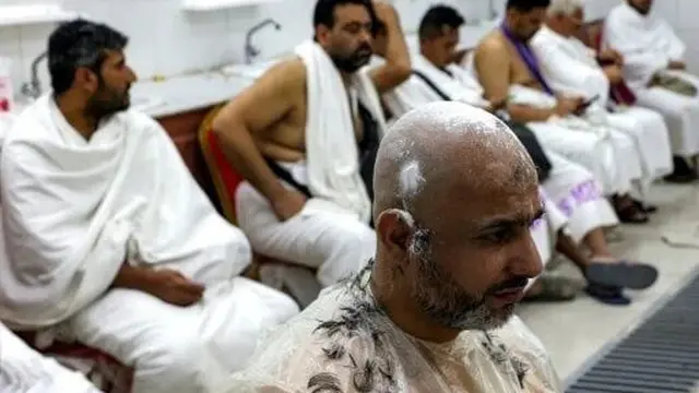 Jemaah haji 2025 menunggu di luar tempat pangkas rambut untuk dipotong rambut di Mina pada 6 Juni 2025. (HAZEM BADER/AFP)