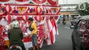 Seorang pedagang bendera merapikan umbul-umbul dan bendera yang di jual di Sepanjang Jalan Jatinegara, Jakarta, Selasa (2/8/2022). Jelang peringatan HUT Kemerdekaan RI ke-77, pedagang musiman bendera  mulai bermunculan mereka memanfaatkan trotoar untuk memajang dagangannya, mulai dari umbul-umbul, bendera, hingga ornamen khas merah putih lainnya dengan harga yang tawarkan juga bervariasi, mulai dari Rp. 5.000 ,- hingga Rp. 300.000,. (Liputan6.com/Faizal Fanani)