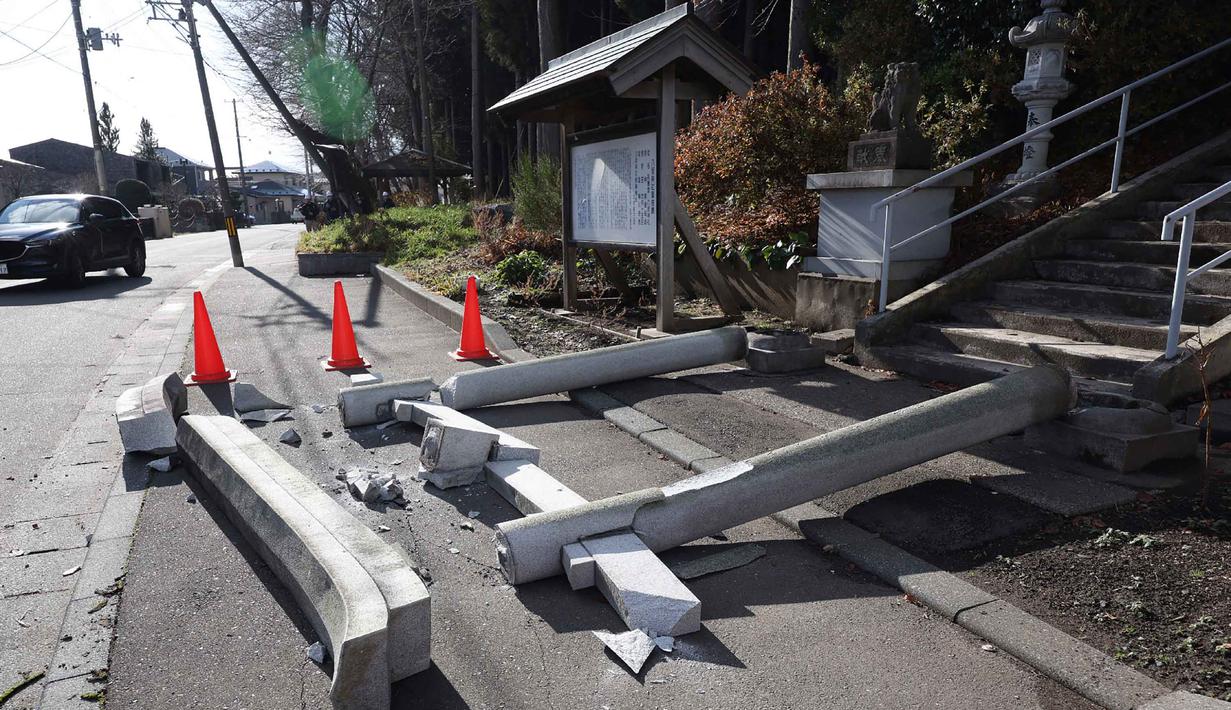 Gempa dengan kekuatan 7,5 magnitudo itu menyebabkan setidaknya 30 orang terluka. Tampak dalam foto, gerbang torii di pintu masuk Kuil Yasaka terlihat runtuh menimpa trotoar di Kota Hachinohe, Prefektur Aomori, Jepang, pada Selasa 9 Desember 2025. (JIJI Press/Japan OUT/AFP)