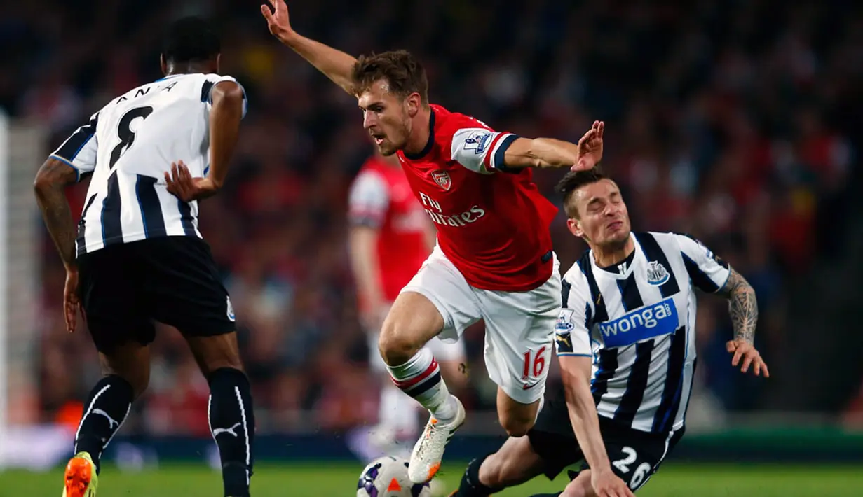 Aaron Ramsey (Arsenal) mencoba menghindari tackling pemain Newcastle United, Mathieu Debuchy dalam laga lanjutan Liga Primer Inggris di Stadion Emirates, London (28/4/2014). (REUTERS/Eddie Keogh)