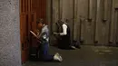 Umat Katolik berdoa di depan kapel Basilica of Our Lady of Guadalupe yang tutup di Mexico City, Meksiko, Jumat (10/4/2020). Pandemi virus corona COVID-19 yang melanda dunia membuat perayaan Jumat Agung berlangsung terbatas untuk menghindari penyebaran penyakit. (AP Photo/Rebecca Blackwell)