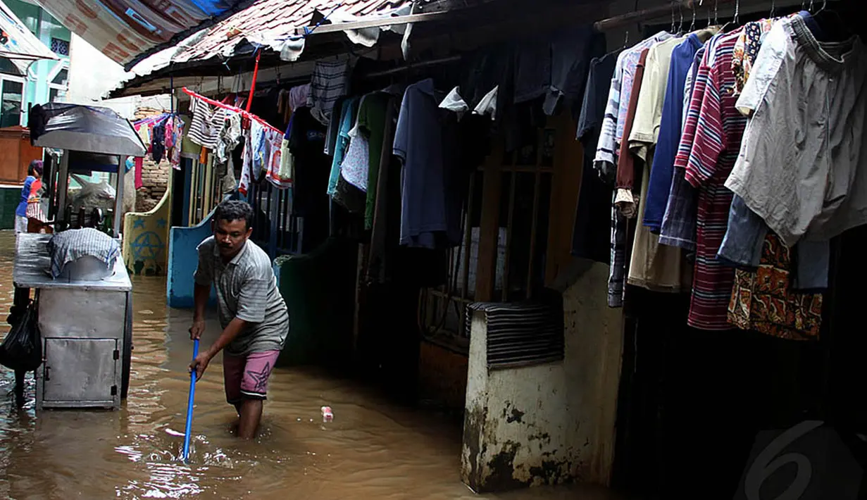 Aktivitas warga Kampung Pulo, Jakarta Timur, yang sejak Kamis (13/11/2014) subuh, rumah mereka terendam banjir. (Liputan6.com/Johan Tallo)