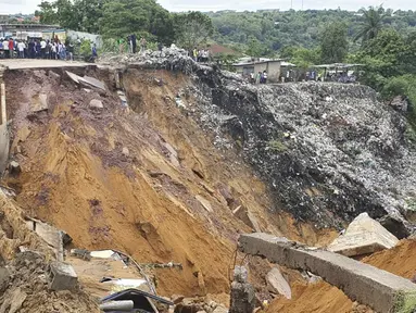 Permukaan jalan ambruk oleh tanah longsor yang disebabkan hujan lebat melanda distrik Lemba, Kinshasa di Republik Demokratik Kongo pada Selasa (26/11/2019). Musibah tersebut telah mengakibatkan jalan raya yang menjadi penghubung antar desa putus total. (AFP/Ange Kasongo)