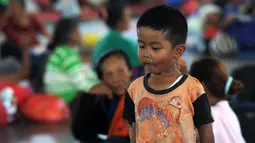 Seorang anak laki-laki berdiri di tempat penampungan sementara di Kabupaten Klungkung, Bali (22/9). Pengungsi tercatat berada di pos pengungsi GOR Swecaparu Kecamatan Klungkung, Kabupaten Klungkung sebanyak 378 jiwa. (AFP Photo/Sonny Tumbelaka)