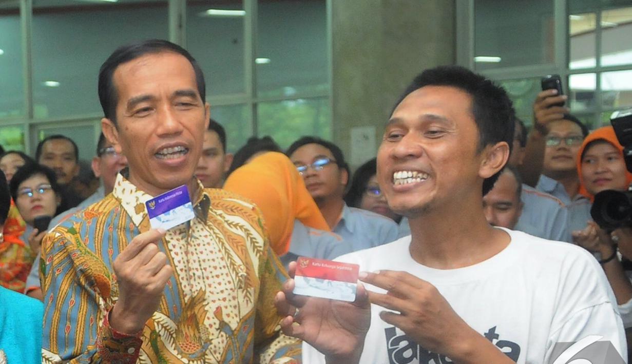 Presiden Jokowi bersama seorang warga menunjukkan Kartu Indonesia Sehat di Kantor Pos Pasar Baru, Jakarta, Senin (3/11/2014). (Liputan6.com/Herman Zakharia)