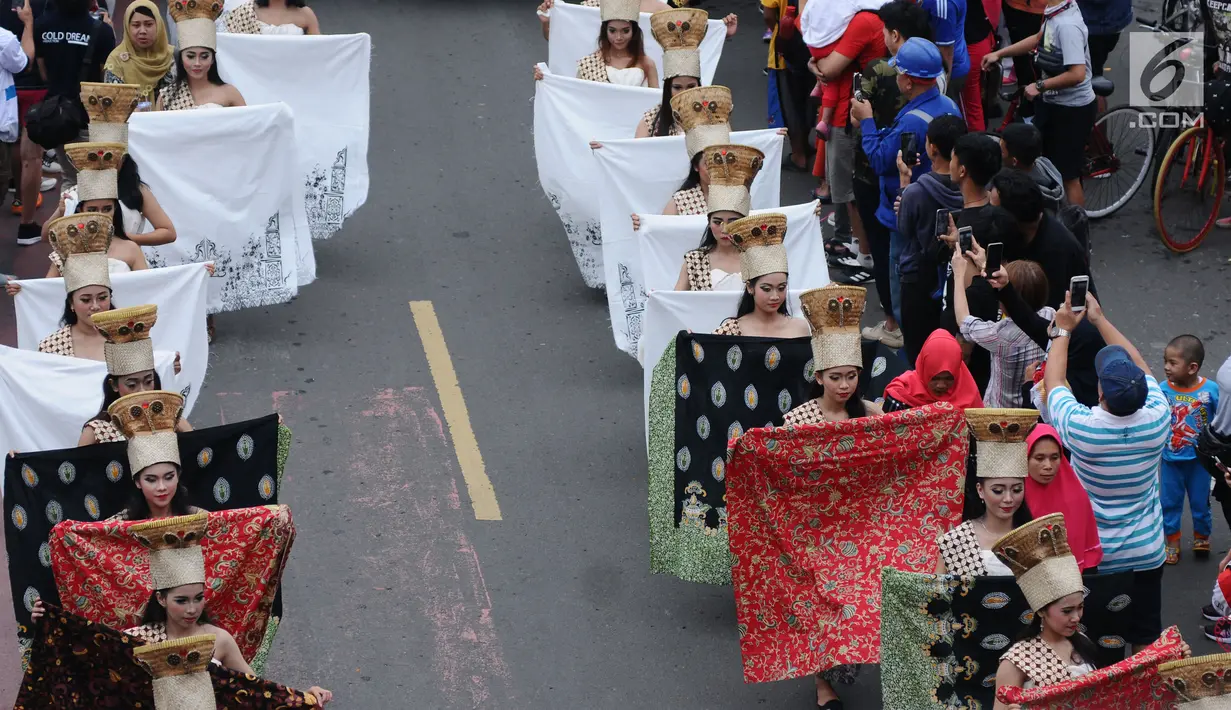 Model membawa beberapa batik saat berpawai pada perayaan Hari Batik Nasional di Hari Bebas Kendaraan di kawasan Bundaran HI, Jakarta, Minggu (1/10). Parade Batik Nusantara ini perayaan Hari Batik Nasional 2 Oktober. (Liputan6.com/Helmi Fithriansyah)