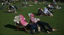 Warga Inggris berjemur di sebuah taman di pusat kota London,  Inggris, Sabtu (8/4). Sinar matahari yang hangat dimanfaatkan warga Inggris untuk berjemur dan bersantai dengan keluarga atau teman di taman-taman kota. (AFP PHOTO / Daniel Leal-Olivas)