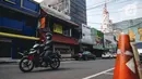 Pengendara motor melintas di depan pertokoan yang tutup di kawasan little Tokyo, Blok M, Jakarta, Rabu (21/7/2021). Pemerintah resmi menetapkan pemberlakuan pembatasan kegiatan masyarakat (PPKM) level 4 hingga 25 Juli mendatang untuk mencegah penyebaran virus Covid-19. (Liputan6.comn/Faizal Fanani)