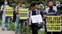 Sejumlah aktivis Koalisi Pejalan Kaki melakukan aksi peduli pejalan kaki di kawasan pedestrian Kasablanka, Jakarta, Kamis (22/8). Mereka menyerukan agar tidak menggunakan trotoar sebagai tempat parkir dan berjualan.(Liputan6.com/JohanTallo)