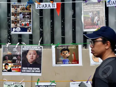 Warga melintas diantara gambar koruptor dan pegiat antikorupsi di MH Thamrin, Jakarta, Minggu (18/1/2015). (Liputan6.com/Miftahul Hayat)