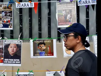 Warga melintas diantara gambar koruptor dan pegiat antikorupsi di MH Thamrin, Jakarta, Minggu (18/1/2015). (Liputan6.com/Miftahul Hayat)