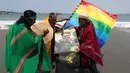 Dukun Peru memegang poster Presiden Brasil Jair Bolsonaro selama ritual tahun baru  di pantai Agua Dulce, Lima, Kamis (27/12). Ritual dimaksudkan untuk membawa kekuatan dan energi ke seluruh dunia sehingga ada kedamaian dan ketenangan. (AP/Martin Mejia)