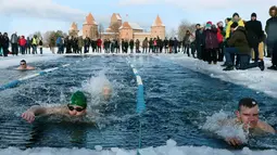 Suasana kompetisi renang musim dingin tahunan dengan air es beku di Trakai, Lituania (24/2). Para peserta tetap antusias mengikuti lomba walaupun dengan suhu di luar hingga minus 12 derajat Celcius. (AFP Photo/Petras Malukas)