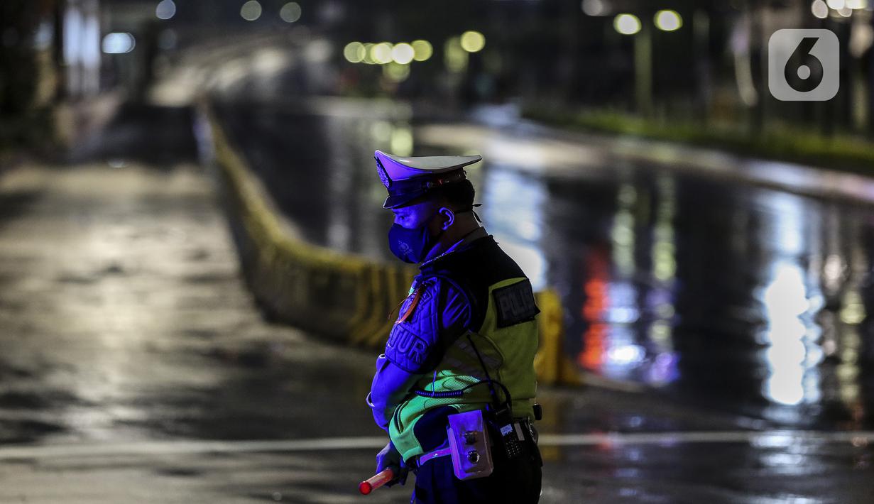 Polisi berjaga saat diberlakukannya Car Free Night dan Crowd Free Night di Jalan Sudirman-MH Thamrin, Jakarta (31/12/2020). Jalan Sudirman-MH Thamrin ditutup pada malam pergantian tahun untuk mencegah kerumunan warga. (Liputan6.com/Johan Tallo)
