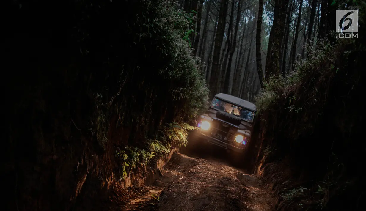 Mobil offroad 4x4 klasik Land Rover menerobos jalan sempit saat wisata offroad menuju trek Sukawana-Cikole di Kab Bandung Barat, Jawa Barat, Jumat (19/10). Wisata offroad di Kab Bandung Barat ini memiliki panjang trek 18 km. (Liputan6.com/Faizal Fanani)