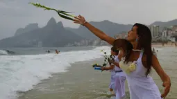 Masyarakat Brasil percaya dengan melakukan ritual Lemanja akan membawa kedamaian dan kebahagiaan pada hari-hari mereka, Pantai Arpoador, Rio de Janeiro, Brasil, Senin (2/2/2015). (AFP Photo/Yasuyoshi Chiba)