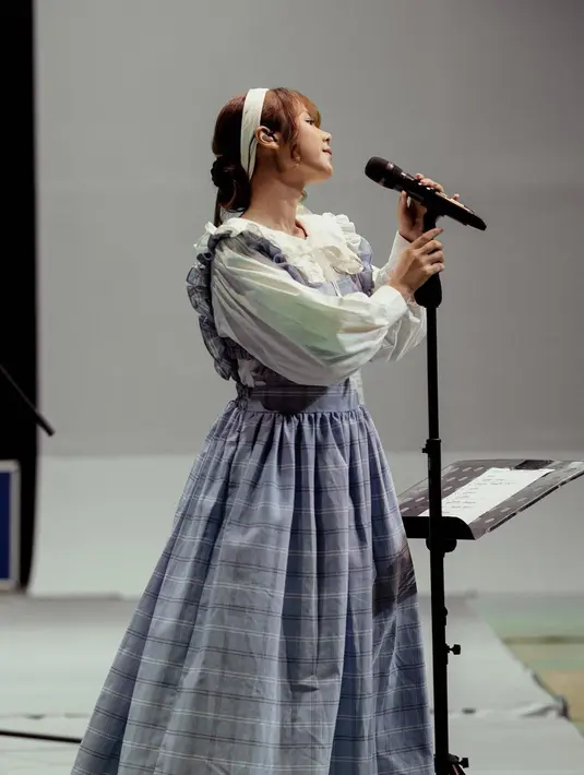 Seperti potret ini, pelantun “Rayuan Perempuan Gila” itu tampil anggun dalam balutan collared dress dengan motif gingham warna biru muda.  [@cakecaine]