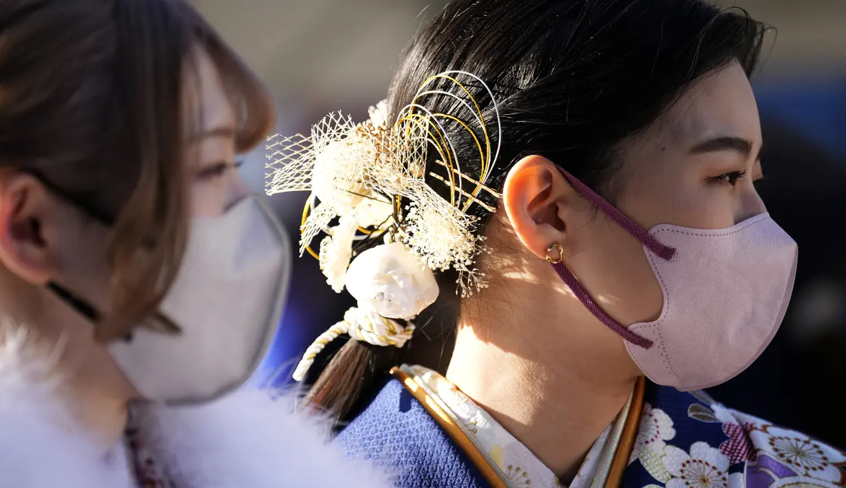 Perempuan Jepang berkimono yang merayakan ulang tahun ke-20 antre memasuki tempat untuk berpartisipasi dalam upacara resmi, yang biasa disebut upacara Kedewasaan di Yokohama dekat Tokyo, Senin (9/1/2023). Diadakan setiap tahun pada hari Senin kedua di bulan Januari, pemerintah kota setempat merayakan Hari Kedewasaan atau Seiji no Hi. (AP Photo/Eugene Hoshiko)