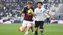 Pemain AC Milan, Charles De Ketelaere, berebut bola dengan pemain Spezia, Ethan Ampadu, pada laga Liga Italia di Stadion Alberto-Picco, Minggu (14/5/2024). AC Milan takluk dengan skor 0-2 dari Spezia. (AFP/Vincenzo Pinto)
