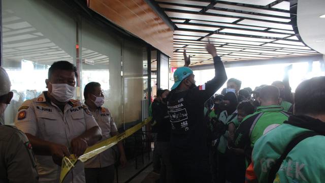 Satpol PP Kota Depok menyegel McD Ciplaz Depok dikarenakan melanggar PPKM Kota Depok. (Liputan6.com/Dicky Agung Prihanto)