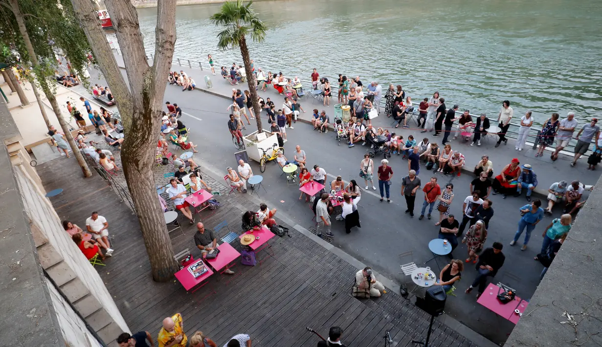 Sejumlah warga menikmati musik saat berkumpul di tepi sungai Seine sebagai bagian dari acara musim panas Paris Plages di Paris, Prancis (7/7). (AFP Photo/Francois Guillot)