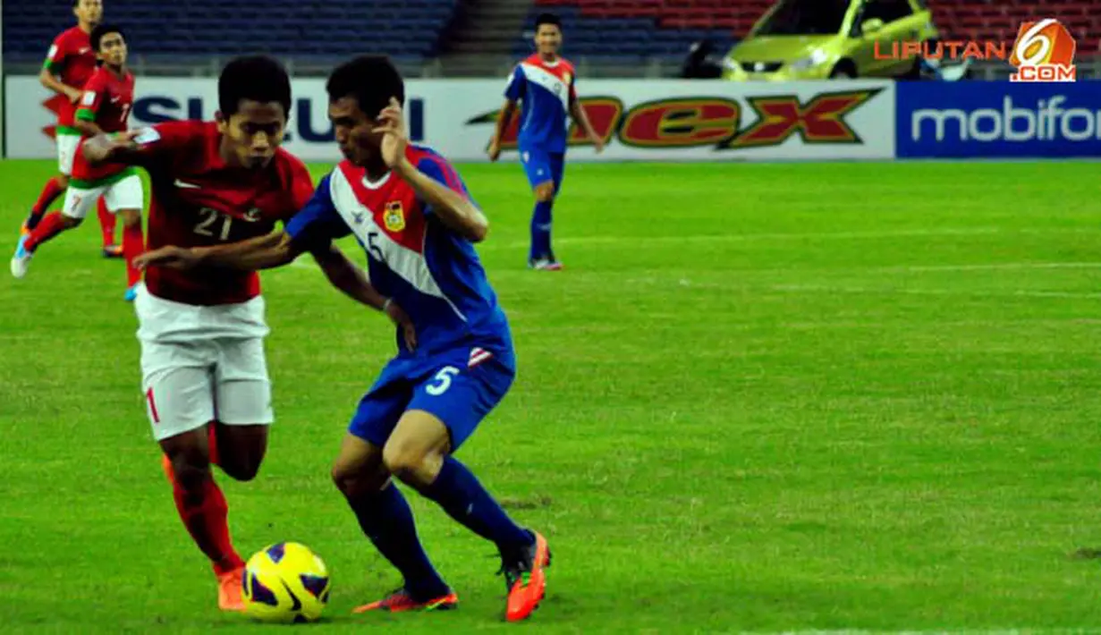 Pemain Timnas Indonesia Andik Vermansyah dapat hadangan dari pemain Timnas Laos, Khampoumy Hanevilay di Laga Piala AFF Suzuki 2012 Minggu 25 November 2012 di  Stadion Bukit Jalil, Kuala Lumpur, Malaysia. Pertandingan berakhir dengan skor 2-2.