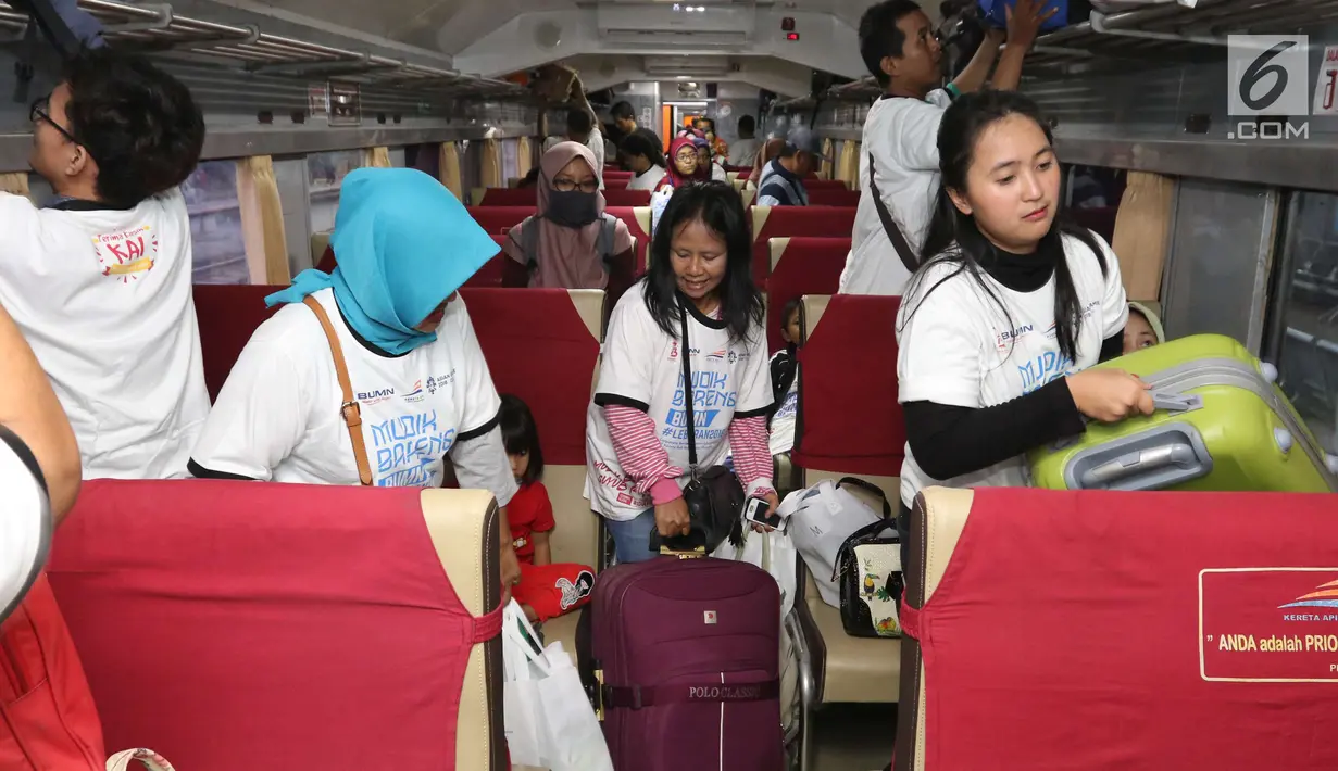 Para peserta mudik gratis PT KAI menaruh barang di kereta Brantas Lebaran jurusan Blitar di Stasiun Senen, Jakarta, Selasa (5/6). Masyarakat wajib membawa KTP dan Kartu Keluarga. (Liputan6.com/Angga Yuniar)