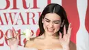 Penyanyi cantik Dua Lipa membawa mawar putih di karpet merah acara Brit Awards 2018, London, Rabu (21/2). Brit Awards dihiasi mawar putih sebagai lambang solidaritas melawan pelecehan seksual yang ramai di industri hiburan. (Vianney Le Caer/Invision/AP)