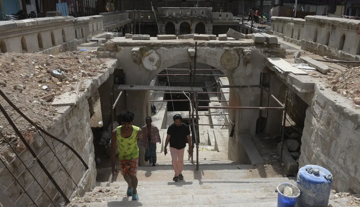Orang-orang pergi setelah mandi di sumur tangga Bansilalpet berusia abad ke-18 yang sedang menjalani pekerjaan restorasi di Secunderabad, kota kembar Hyderabad, India (24/8/2022). (AFP/Noah Seelam)