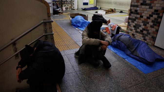 Para tunawisma tidur di lantai Stasiun Shinjuku, Tokyo, Jepang, Kamis (9/1/2020). Seperti Amerika Serikat, Jepang memiliki tingkat kemiskinan yang relatif tinggi untuk negara kaya. (AP Photo/Jae C. Hong)