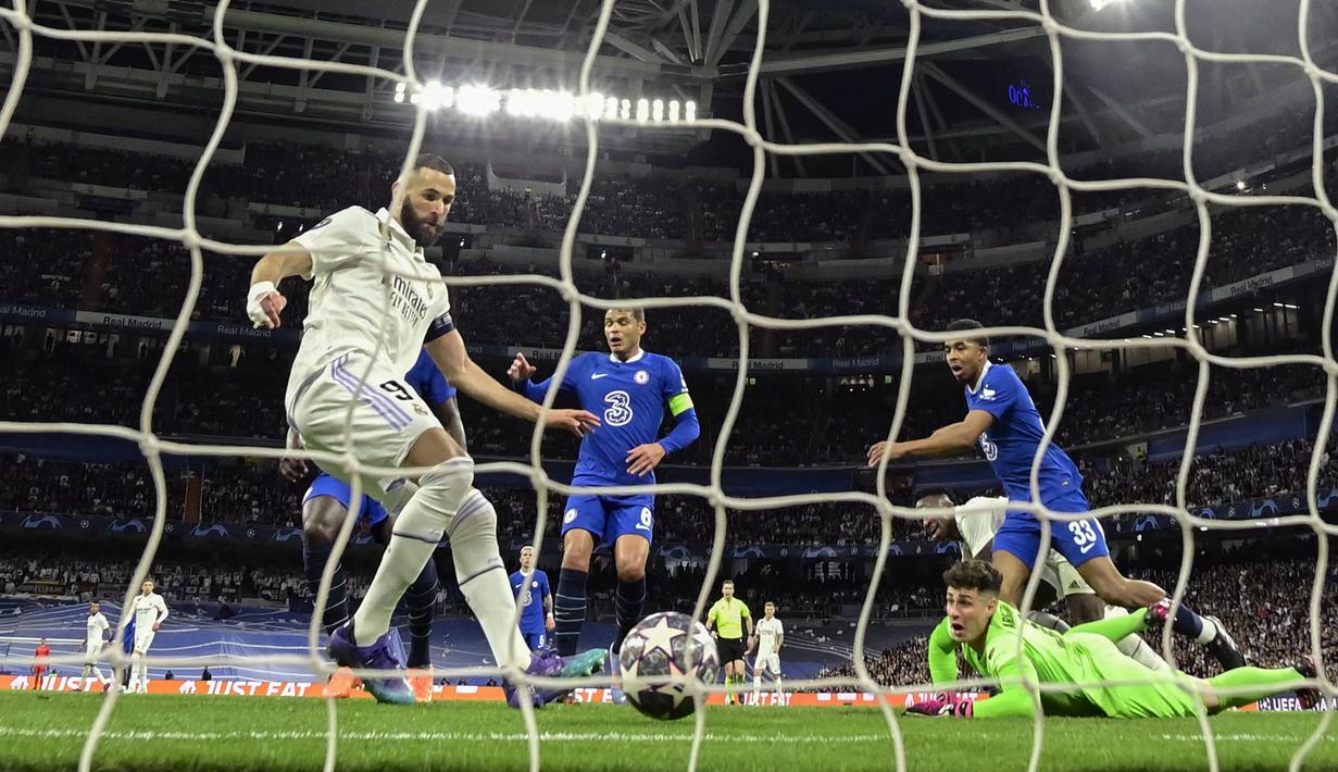 Pemain Real Madrid, Karim Benzema (kiri) mencetak gol pertama timnya ke gawang Chelsea pada laga leg pertama Liga Champions 2022/2023 di Santiago Bernabeu, Madrid, Kamis (13/04/2023) WIB. Los Blancos menang dengan skor 2-0. (AFP/Javier Soriano)