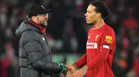 Pelatih Liverpool, Juergen Klopp, bersalaman dengan Virgil Van Dijk usai mengalahkan Brighton pada laga Premier League di Stadion Anfield, Liverpool, Sabtu (1/12). Liverpool menang 2-1 atas Brighton. (AFP/Paul Ellis)