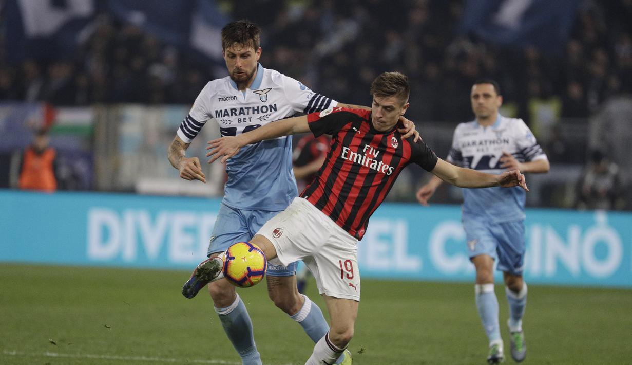 Bomber AC Milan, Krzysztof Piatek berduel dengan Francesco Acerbi pada laga semifinal Coppa Italia yang berlangsung di stadion Olimpico, Roma, Rabu (27/2). AC Milan bermain imbang 0-0 kontra SS Lazio. (AP Newsroom)