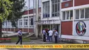 Petugas polisi berdiri di depan gedung sekolah menengah setelah insiden penembakan di Sanski Most, barat laut ibu kota Bosnia, Sarajevo, Rabu (21/8/2024). (AP Photo/Edvin Zulic)